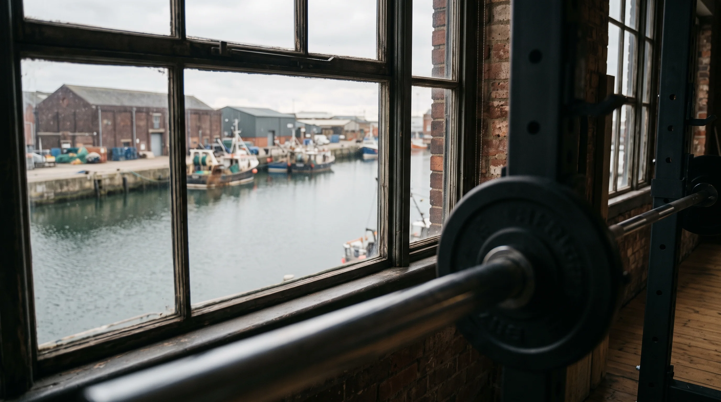 The harbour water seen through the studio window, the edge of a rack soft in the foreground